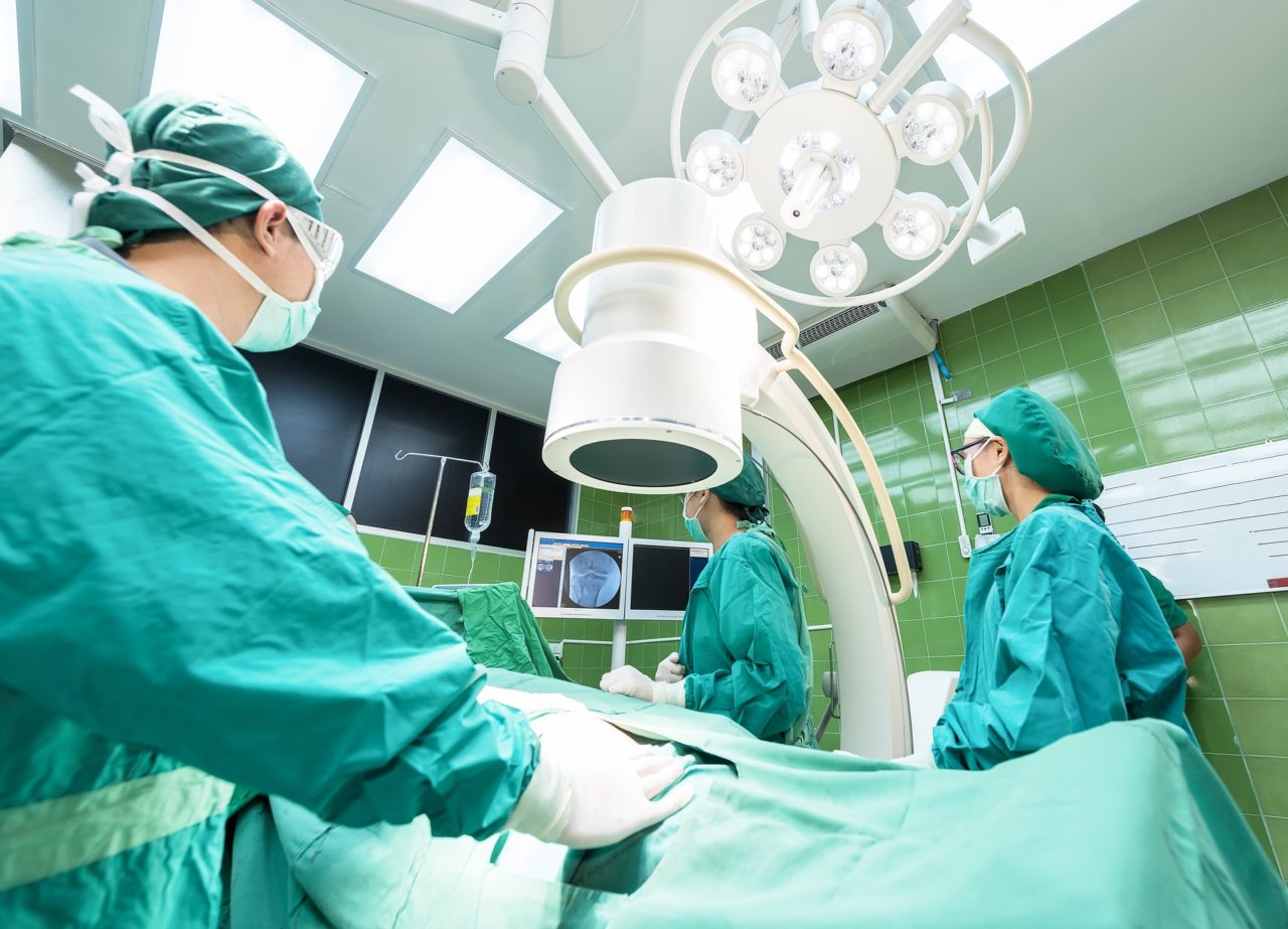Immagine in una sala operatoria con tre medici.