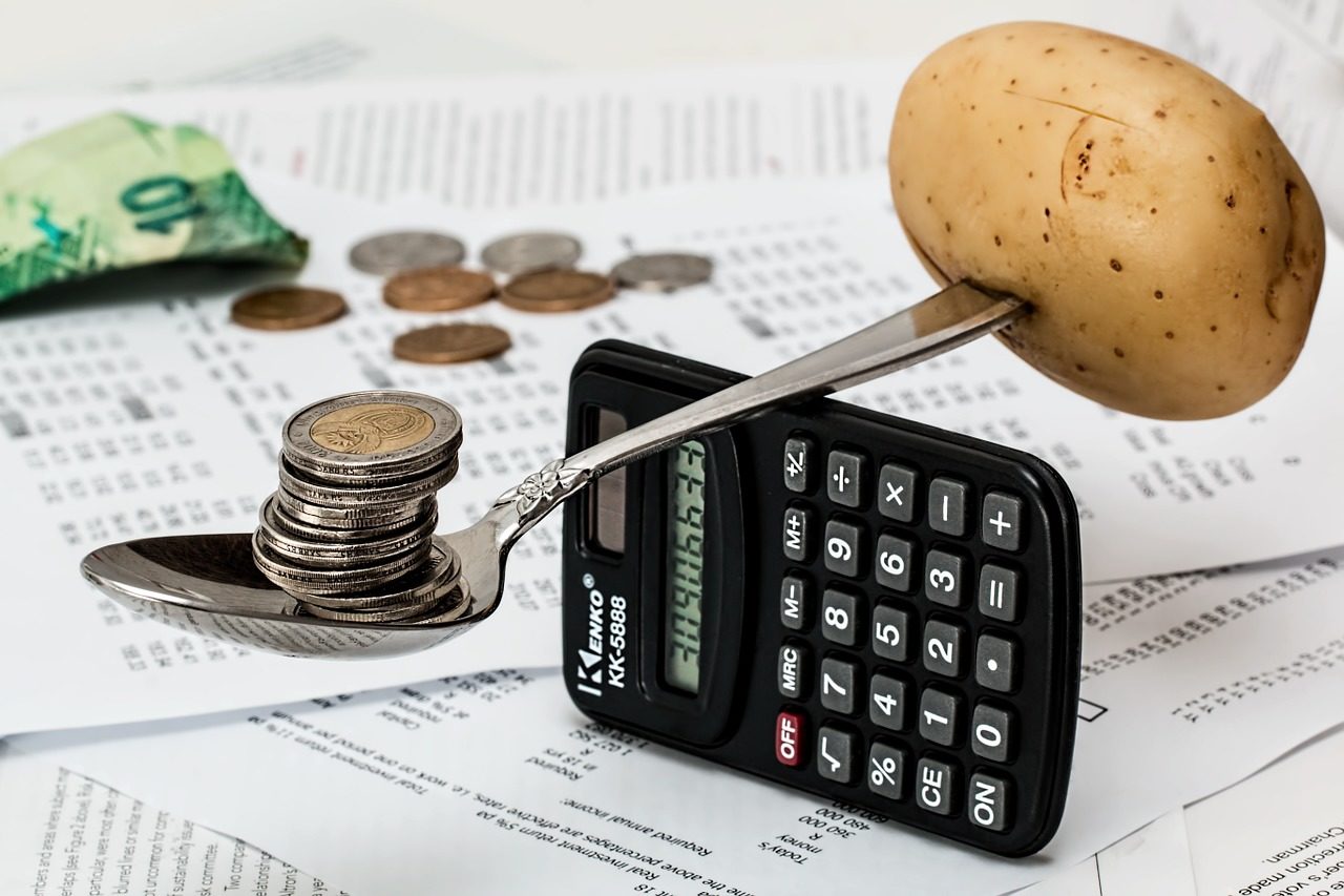 Delle monete, del cibo e una calcolatrice per rappresentare il Rei.